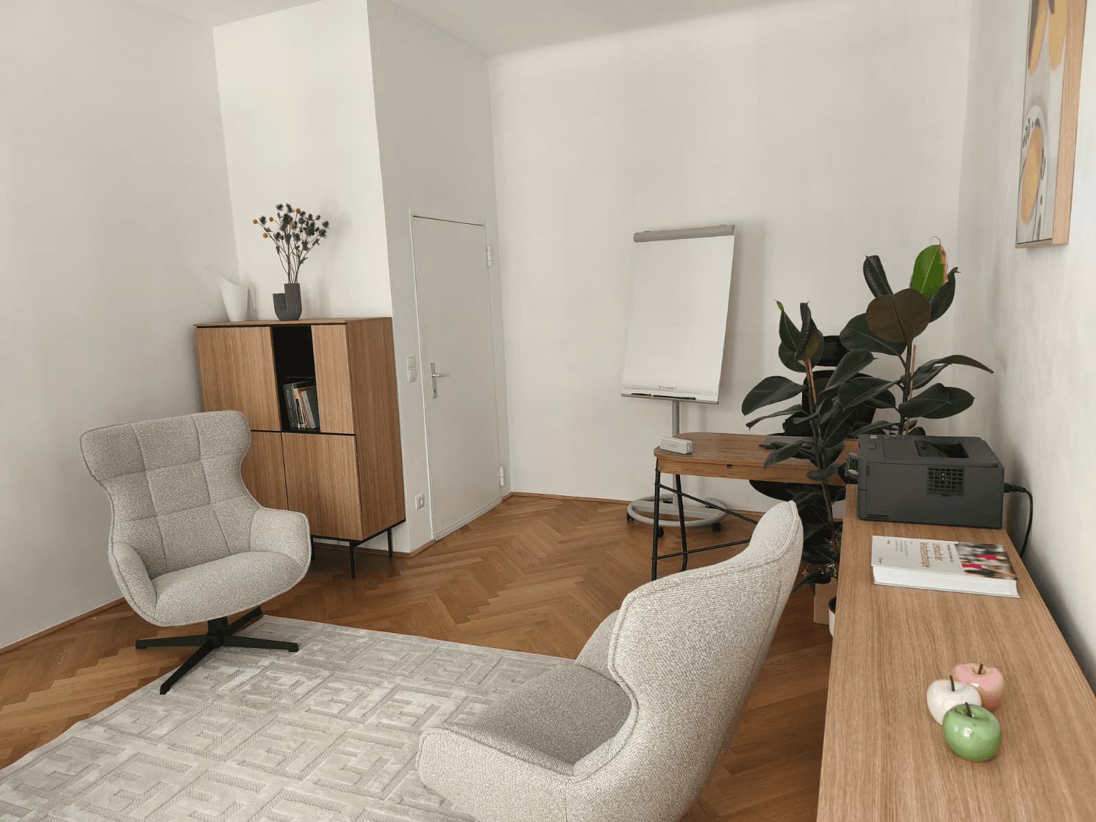 Praxisraum mit Sesseln, Pflanzen und Flipchart